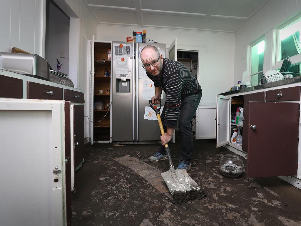 Benjamin Cullen, of Ewing Avenue in Kingston Beach, clearing putrid mud from his kitchen floor. Picture: SAM ROSEWARNE