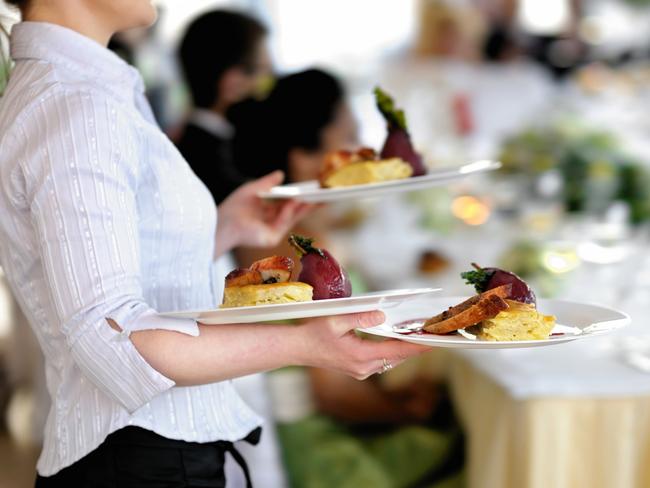 Waitress carrying three plates with meat dishGeneric photo of woman working in hospitality industry