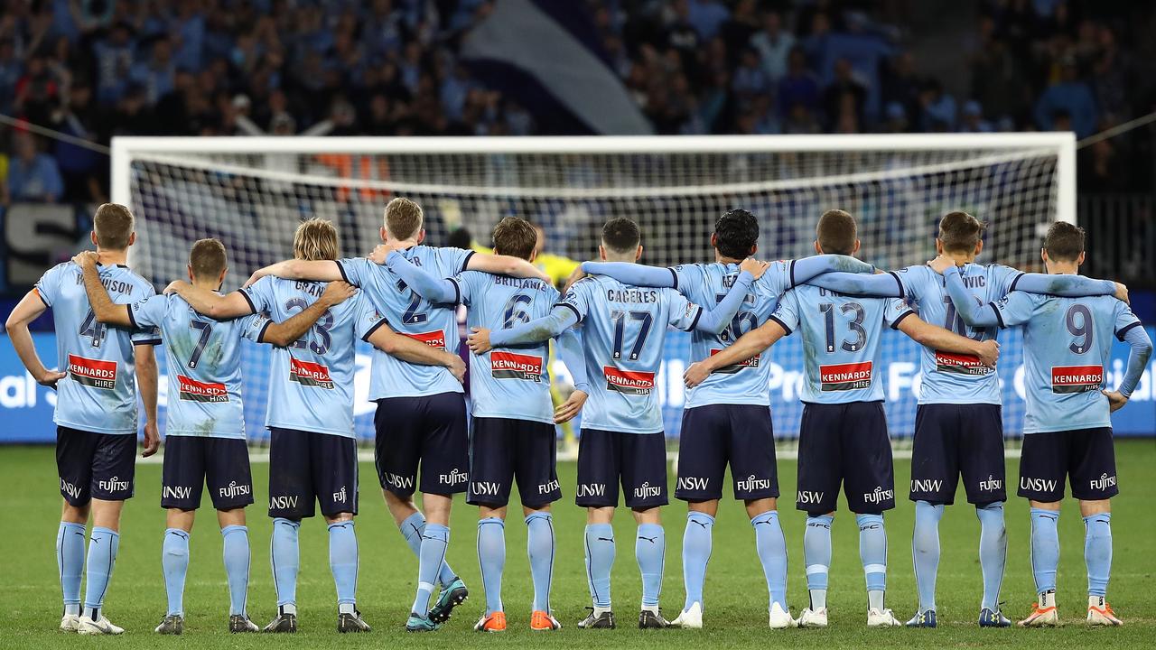 Sydney FC players, arm-in-arm, during Sunday’s grand final penalty shootout.