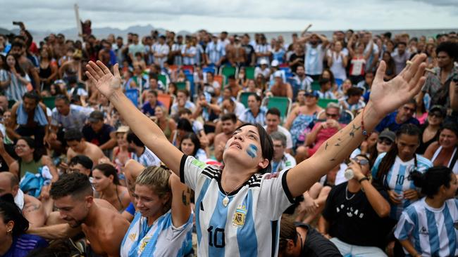 Fans of Argentina react while watching the live broadcast of the Qatar 2022 World Cup final football match between France and Argentina at the Copacabana beach in Rio de Janeiro, Brazil.