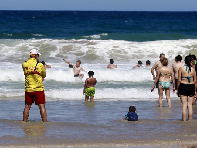 Volunteer Surf Life Savers looking over swimmers enjoying the sun and ocean at Surfers Paradise Beach on a hot Boxing Day. Picture: Jerad Williams