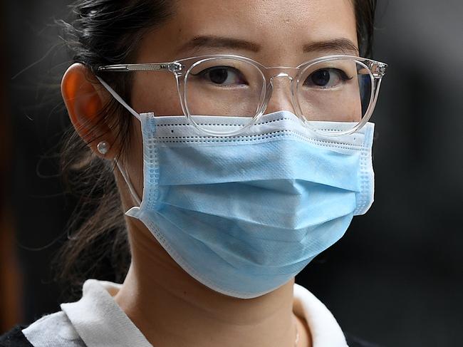 A woman wearing a face mask as a preventative measure against coronavirus COVID-19 in Sydney, Monday, March 16, 2020. (AAP Image/Joel Carrett) NO ARCHIVING