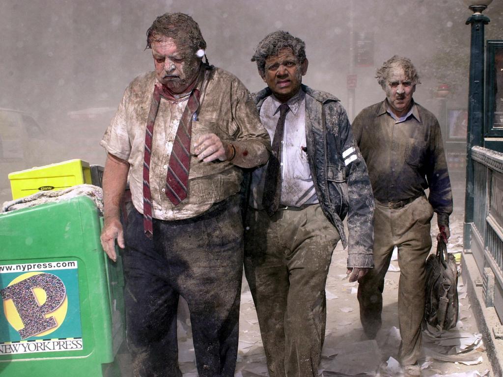 Joseph Kelly, Srinath Jinadasa and George Sleigh covered in dust and debris as they walk away from the World Trade Centre. Picture: Splash News