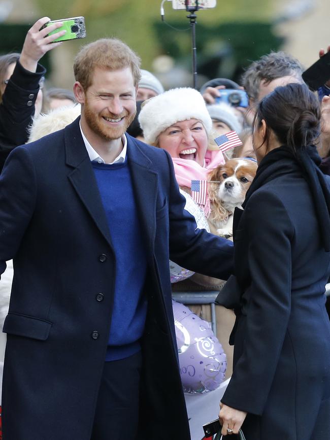 Britain’s Prince Harry and his fiancee Meghan Markle meet a fan with a dog decorated with american flags as they arrive for a visit to Cardiff Castle in Cardiff, Wales, Thursday, Jan.18, 2018. Picture: AP
