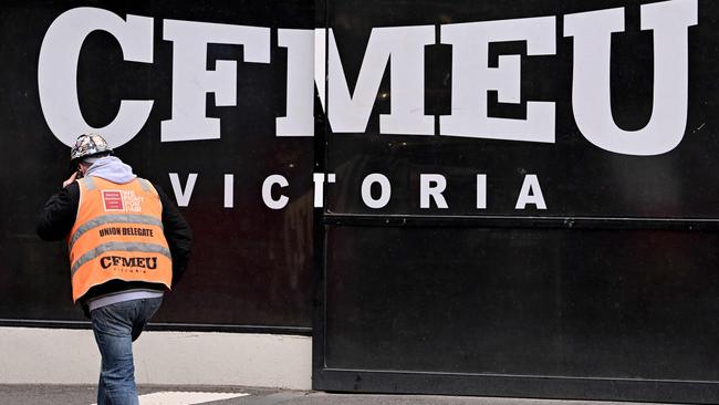 A union official walks past the Victorian headquarters of the Construction, Forestry and Maritime Employees Union (CFMEU) in Melbourne on July 17, 2024. Australia on July 17 pledged to clean up one of its most powerful trade unions, which has been tarred by accusations of intimidating "thuggery", corruption and cosy ties to organised crime. (Photo by William WEST / AFP)