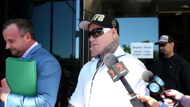 Bikie Ricky Chapman (right, in white shirt) with his lawyer. Picture: AAP