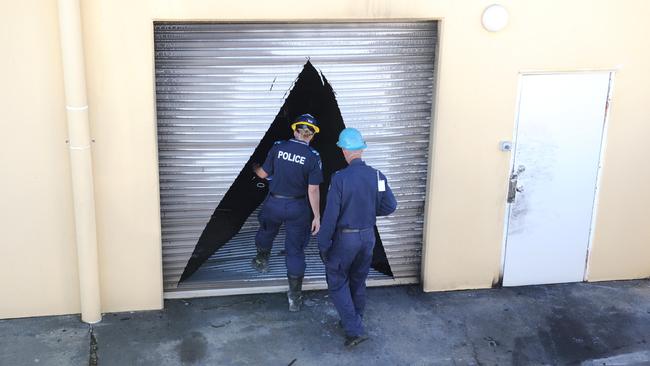 Forensic investigators enter the rear of a building. Picture: Alistair Brightman