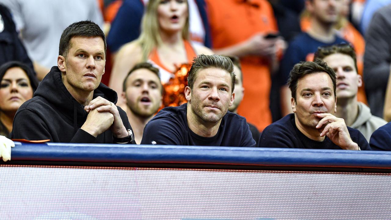 New England Patriots' Tom Brady, left, and Julian Edelman, centre, along with comedian Jimmy Fallon at a college basketball game. (AP Photo/Adrian Kraus)