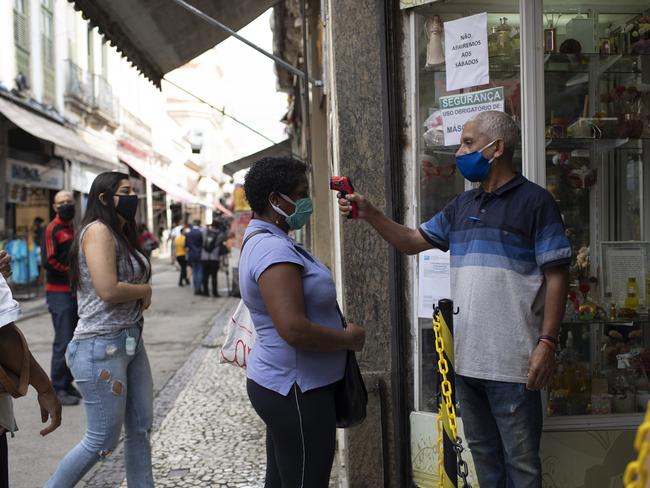 People line up to get their temperature checked before entering a store in downtown Rio de Janeiro. Picture: AP.