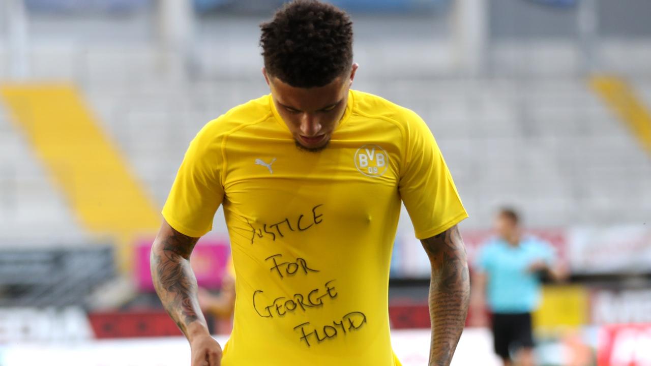 Jadon Sancho shows a "Justice for George Floyd" shirt as he celebrates after scoring his team's second goal. (Photo by Lars Baron / POOL / AFP)