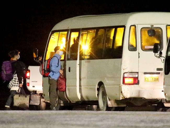 Evacuees wore face masks as they walked the short distance from the plane to three waiting minibuses on Christmas Island. Picture: Nathan Edwards