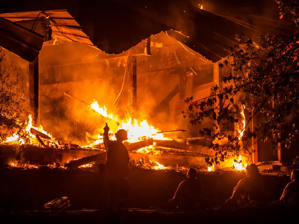 Firefighters look on as a structure burns during the Kincade fire. Picture: Philip Pacheco / AFP.