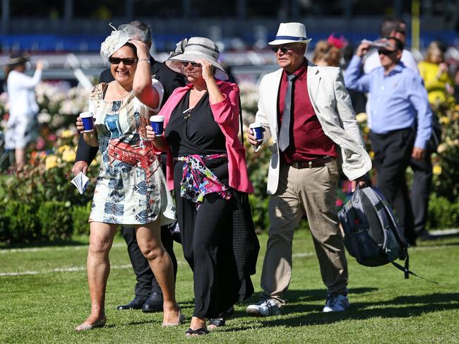 Young and old have to hold on to their hats as the wind sweeps across Flemington. Picture: Mark Stewart