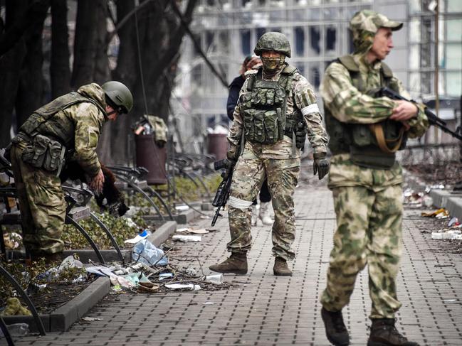 Russian soldiers walks along a street in Mariupol on April 12, 2022, as Russian troops intensify a campaign to take the strategic port city, part of an anticipated massive onslaught across eastern Ukraine, while Russia's President makes a defiant case for the war on Russia's neighbour. (Photo by Alexander NEMENOV / AFP)