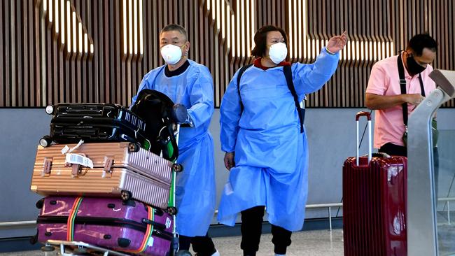 International travellers wearing personal protective equipment arrive at Melbourne's Tullamarine Airport on November 29 as Australia records its first cases of the Omicron variant. Picture: William West/AFP