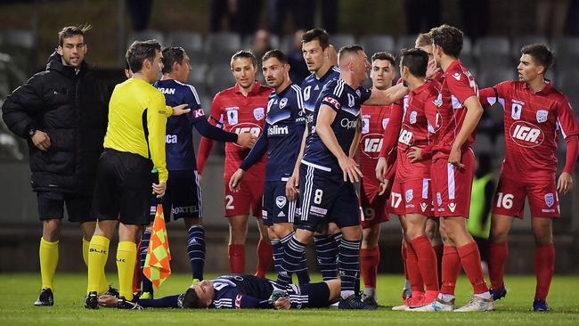 Players react after Taylor Regan of United made contact with Mitch Austin.