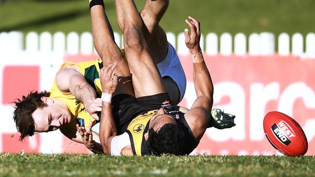 Marlon Motlop of the Tigers is caught holding the ball by Rhyan Mansell of the Eagles.