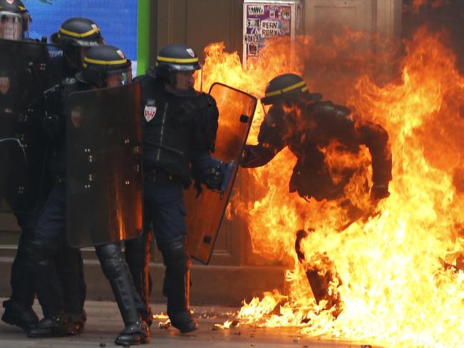 A French riot police officer is surrounded by flames, during a demonstration against the controversial labour reforms of the French government in Paris on September 15, 2016. Picture: AFP PHOTO / Thomas SAMSON