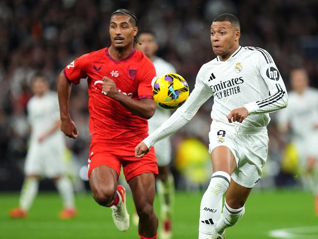 MADRID, SPAIN - DECEMBER 22: Kylian Mbappe of Real Madrid runs with the ball whilst under pressure from Loic Bade of Sevilla FC during the LaLiga match between Real Madrid CF and Sevilla FC at Estadio Santiago Bernabeu on December 22, 2024 in Madrid, Spain. (Photo by Angel Martinez/Getty Images)