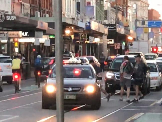 A man swings his skateboard at one of the men and narrowly misses. Picture: Supplied