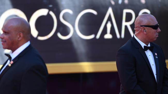 Security members stand guard on the red carpet as guests arrive. Picture: AFP