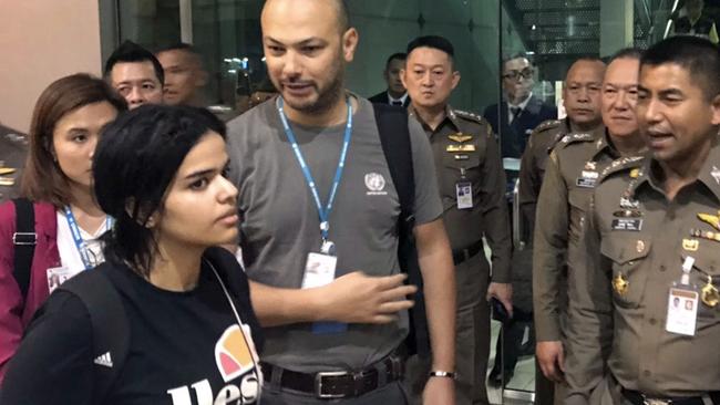 Saudi woman Rahaf Mohammed al-Qunun walks by Chief of Immigration Police Maj. Gen. Surachate Hakparn, right, before leaving the Suvarnabhumi Airport in Bangkok. Picture: AP 