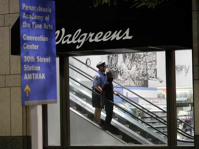 A Philadelphia police officer detains a person inside a damaged pharmacy during the Justice for George Floyd Philadelphia Protest. Picture: AP Photo/Matt Slocum