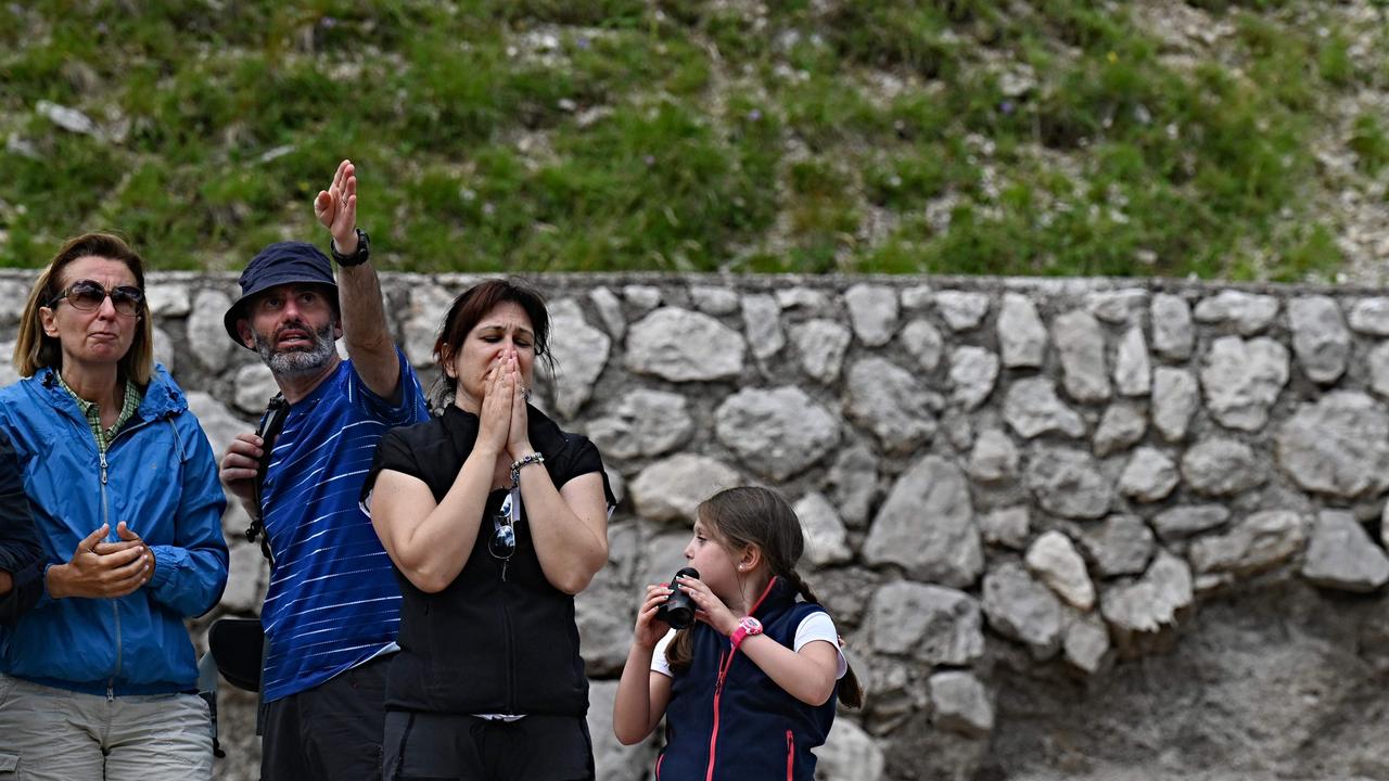 People watch a rescue helicopter at work as it searches for missing hikers. Picture: Tiziana Fabi/AFP