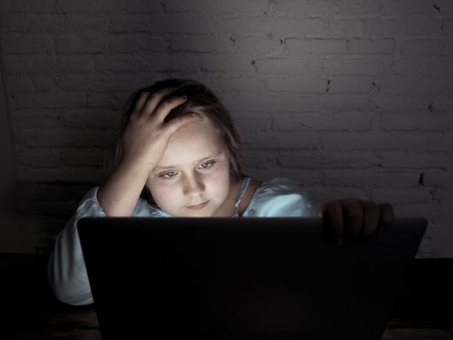 Scared sad girl bullied online on laptop suffering cyber bullying harassment. School girl humiliated on the internet by classmates feeling desperate and intimidated. Children victim of bullying.