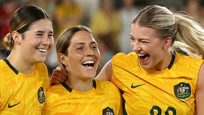 MELBOURNE, AUSTRALIA - FEBRUARY 28: Kyra Cooney-Cross of Australia, Katrina Gorry of Australia and Charlotte Grant of Australia celebrate after winning the AFC Women's Olympic Football Tournament Paris 2024 Asian Qualifier Round 3 match between Australia Matildas and Uzbekistan at Marvel Stadium on February 28, 2024 in Melbourne, Australia. (Photo by Robert Cianflone/Getty Images)