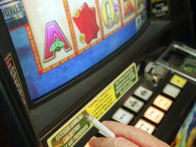 An unamed Victorian smoker crossed the border to play and smoke in the Gol Gol Hotel gaming room 28 Mar 2003. gambling cigarette hand poker machine pokies smoking