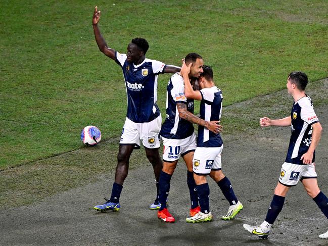 Marco Tulio (second from left) celebrates with his Mariners teammates after scoring against Brisbane Roar. Picture: Bradley Kanaris/Getty Images