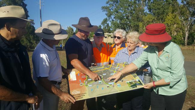 Port Curtis landholder Matthew Neale studies the levee plan with Capricornia MP, Michelle Landry, mayor Margaret Strelow and RRC councillors Tony Williams, Drew Wickerson, Neil Fisher and Rose Swadling.