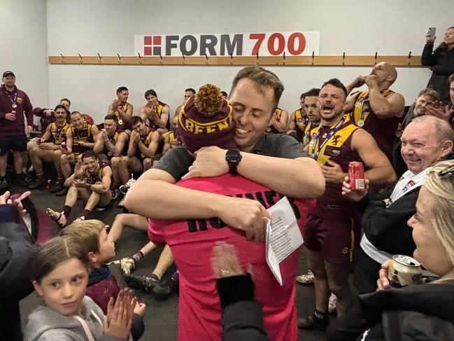 Premiership coach Michael Kinsella gives Liam Wilson, the former coach, a premiership medallion to a roaring reception.