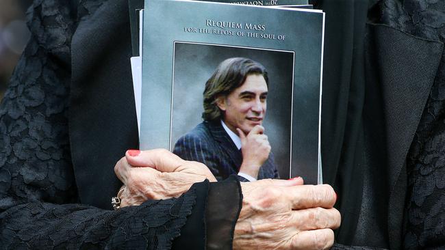 A mourner carries a booklet from the service. Picture: Ian Currie