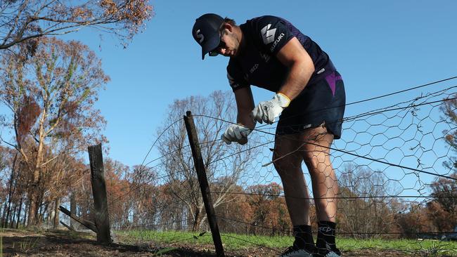 Christian Welch helps with the recovery effort by removing burnt fences.