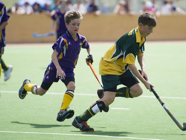 Macarthur Chronicle - Pictured: Julian Cook (Harrington Park) on the ball - Ingleburn Bulldogs (green yellow) versus Harrington Park Hurricanes (purple) - Macarthur District Juniors hockey finals 2014 held at Millwood Avenue, Narellan NSW Australia