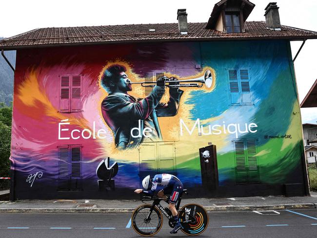 Belgian rider Dries Devenyns, of Soudal Quick-Step, cycles past a mural by artist Nicolas Maurel during the 16th stage of the 110th edition of the Tour de France. The stage was a 22km individual time trial between Passy and Combloux in the French Alps. Picture: Anne-Christine Poujoulat / AFP