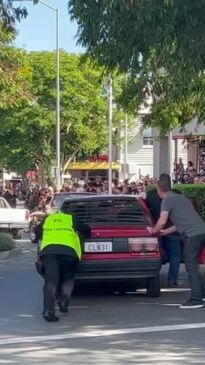 One of the vehicles could not start, so several helpers pushed it down Mary St.