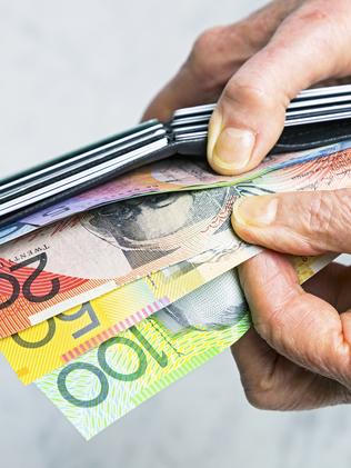 Close-up senior female hands taking Australian banknotes from purse