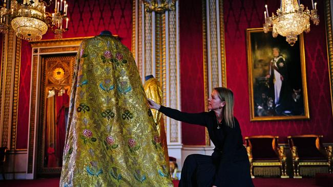 Caroline de Guitaut, deputy surveyor of the King's Works of Art for the Royal Collection Trust, adjusts the imperial mantle, which forms part of the coronation vestments to be worn by Charles during the coronation. Picture: Victoria Jones/Pool/AFP