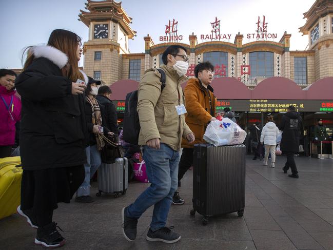 A traveller wears a face mask as he walks outside of the Beijing Railway Station in Beijing. Picture: AP