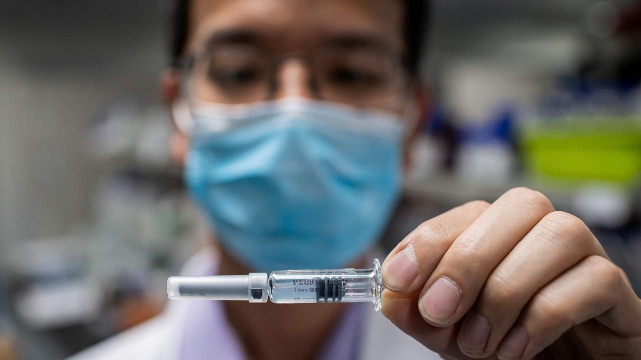 An engineer in Beijing displaying an experimental vaccine for the virus. Picture: Nicolas Asfouri/AFP