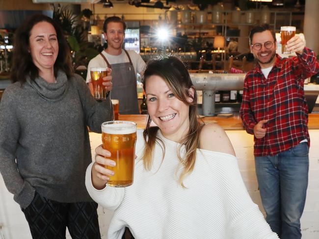 Rachel Nuvolari Moschini (l to r), bartender Ben Wainwright, Hannah Smith and Piotr Szewczuk enjoy a drink at the newly reopened Coogee Pavilion after restrictions were eased. Picture: Rohan Kelly