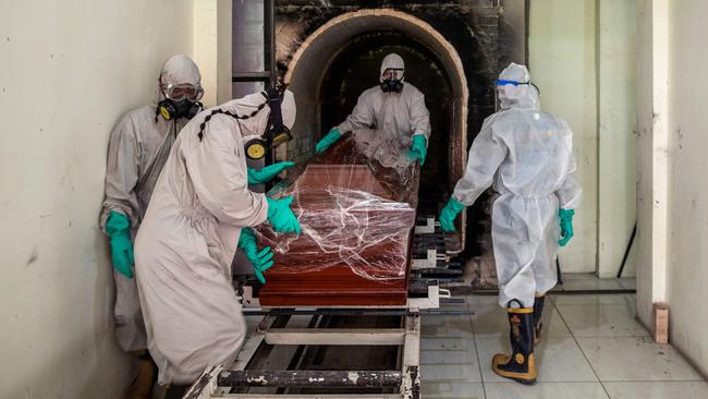 Funeral workers move a sealed coffin containing a COVID-19 victim in Surabaya, Indonesia. Picture: AFP