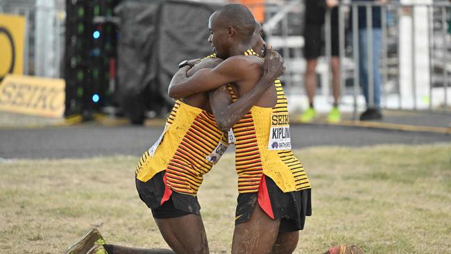 Uganda's Joshua Cheptegei (L) embraces countryman Jacob Kiplimo.