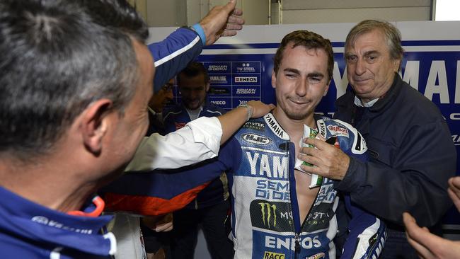 Mechanics congratulate Lorenzo as he is tended to by MotoGP’s chief doctor in the Yamaha garage after the race.