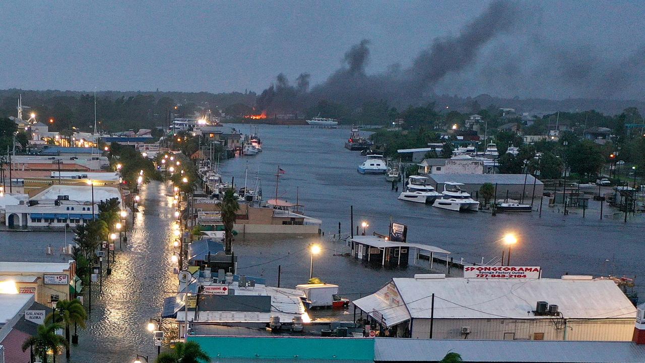 A fire is seen as flood waters inundate Tarpon Springs after Hurricane Idalia passed offshore on August 30, 2023. (Photo by JOE RAEDLE / GETTY IMAGES NORTH AMERICA / Getty Images via AFP)