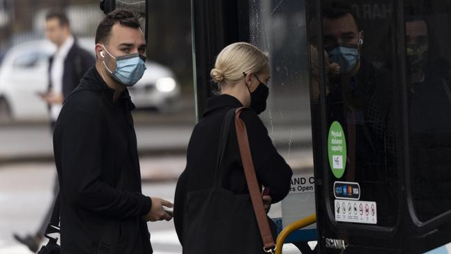 Masked commuters boarding a bus at Bondi Beach on Monday. Picture: Brook Mitchell/Getty Images