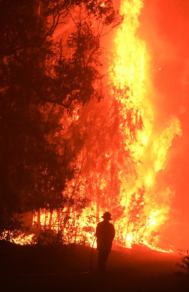 RFS, NSW Fire and Rescue, NPWS officers and local residents fight a bushfire encroaching on properties near Termeil on the Princes Highway between Bateman’s Bay and Ulladulla south of Sydney,Tuesday, December, 3, 2019. Picture: Dean Lewins/AAP